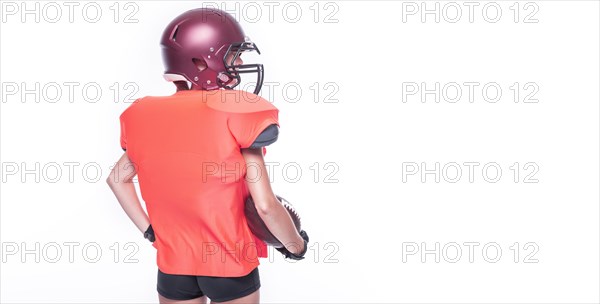 Woman in the uniform of an American football team player posing in the studio. White background. Back view. Sports concept.