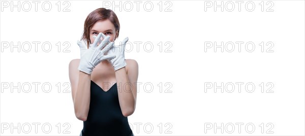 Confused girl in white gloves posing in the studio on a white background. No name portrait
