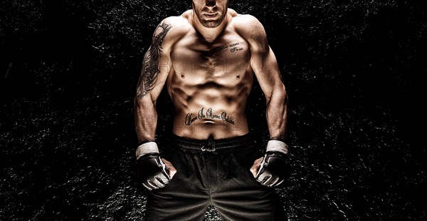 Mixed martial artist posing on a black background. Concept of mma