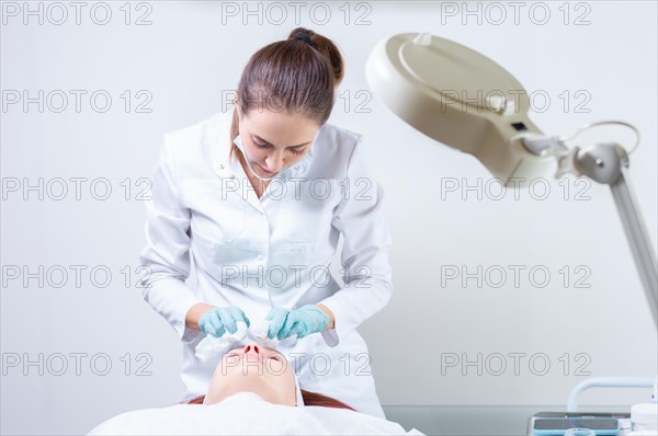 The beautician washes the patient's face before peeling. Skin care concept.