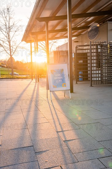 Information sign at the entrance of a swimming pool during a glowing sunset