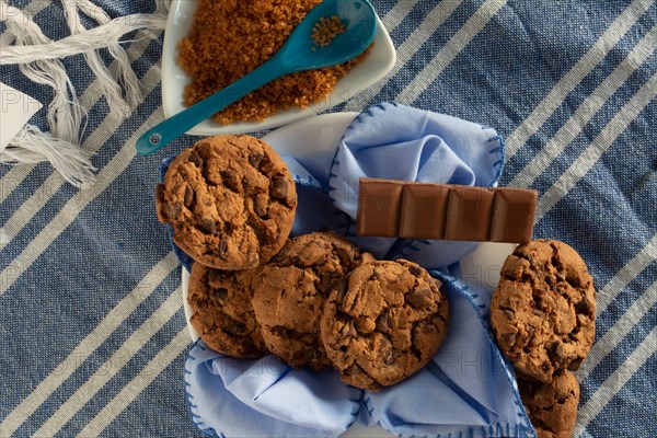 Home-baked cookies with a chocolate bar and brown sugar on the side