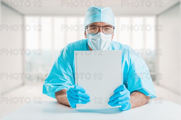 The doctor in the office shows a white textbook in the camera. The concept of medicine and education.