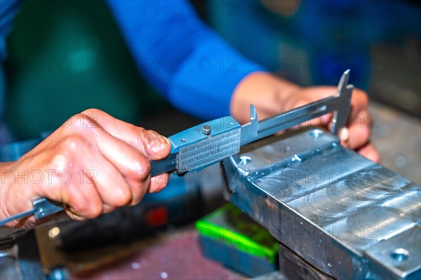 Operator with a cut finger working in a company with milling cutters in a numerical control workshop