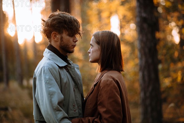 Romantic couple of lovers on a date in the park in cold weather. Fashionable couple in coat