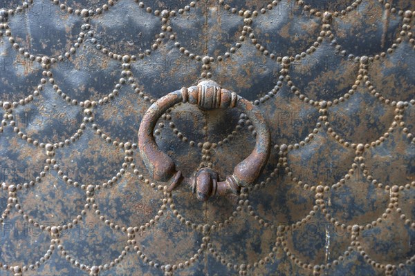 Old door knocker on a metal gate