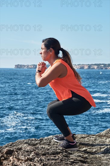 FITNESS WOMAN IN SPORTS SET TRAINING WITH ELASTIC BAND