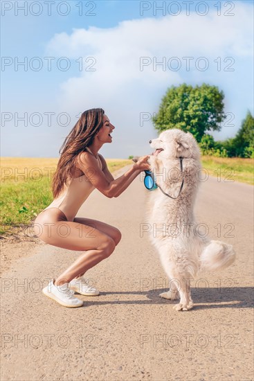 Portrait of a beautiful sexy woman in a bodysuit walking a dog. Love