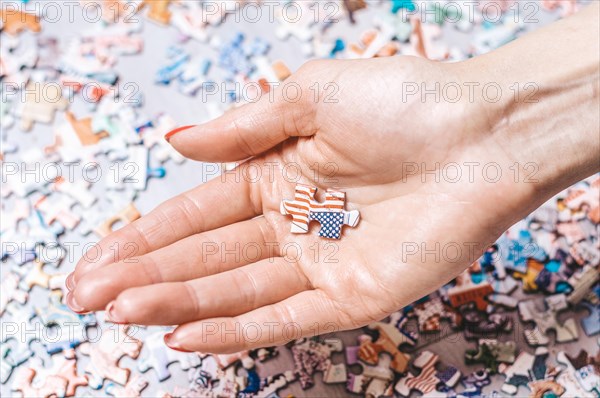 Woman holds puzzle with usa flag. Economic and political concept.