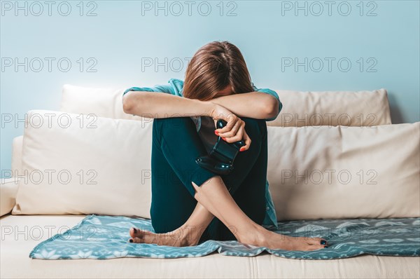 Girl with a joystick in her hands cries because of a defeat in the game. ESports concept.