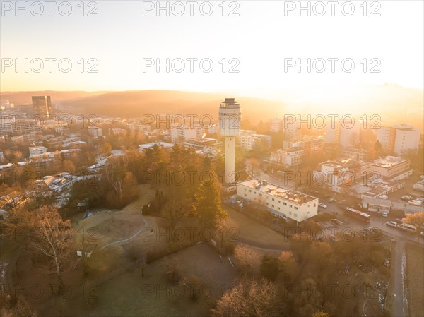 Elevated view of a water tower and the cityscape at sunrise