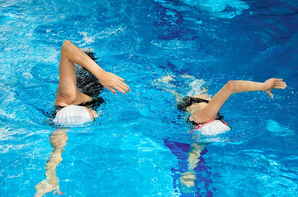 Coach with a student swim in the pool with a crawl