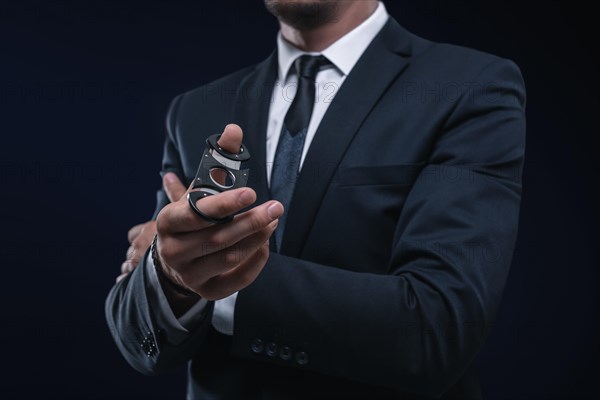 Image of an adult stylish man in a suit with a cigar. Cigar clubs concept.