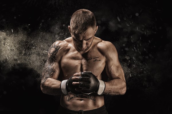 Mixed martial artist posing on a black background. Concept of mma