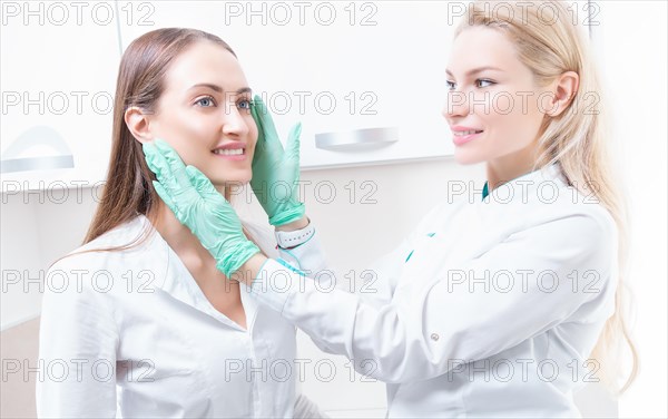 Beautiful girl at a consultation in the salon with a plastic surgeon. Beauty industry concept.