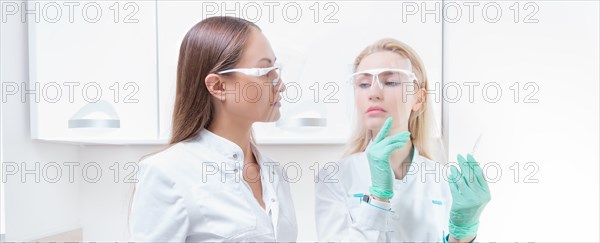 Portrait of two girls in white coats. The concept of cosmetology