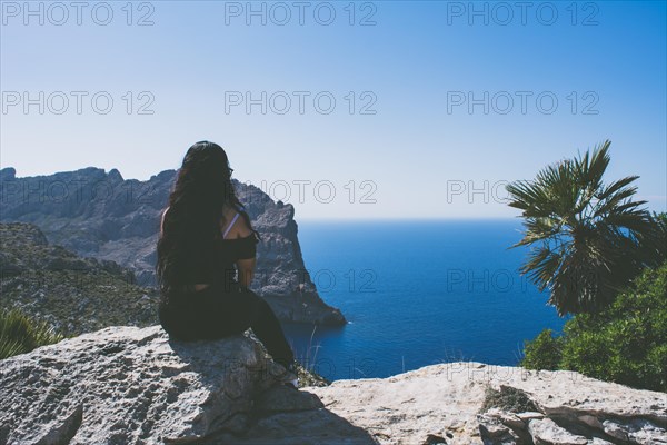 Beautiful portrait of a young latin woman dressed in black in front of the sea
