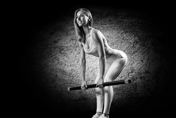 Charming girl does an exercise called deadlift. Bodybar. The concept of fitness