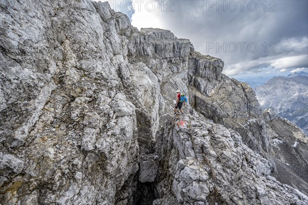 Mountaineer on a narrow rocky mountain path