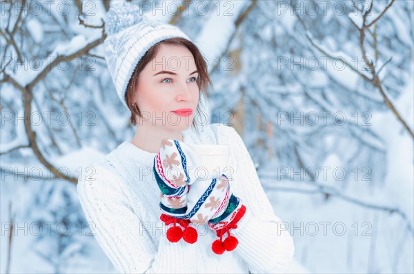 Portrait of a charming girl who holds a mug of hot drink in her hands. Concept of Christmas