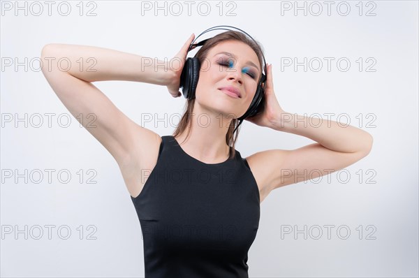 Portrait of a woman in headphones. Immersion in the world of music. DJ concept.