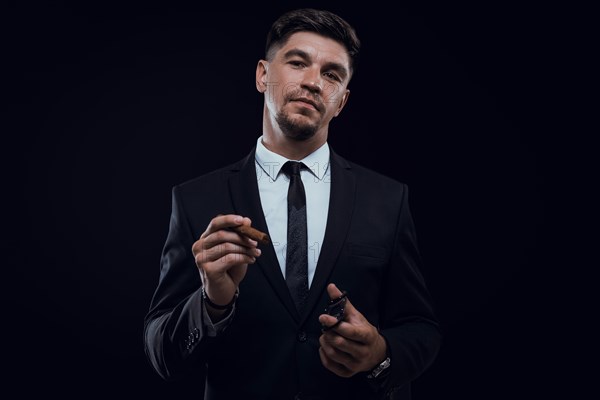 Portrait of a stylish man in a suit with a cigar. Business concept.