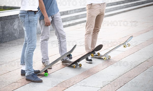 Group of skateboarders are standing near their boards and are preparing to begin training
