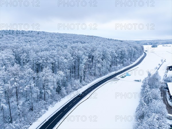 The aerial view shows a road winding through the snow-covered landscape