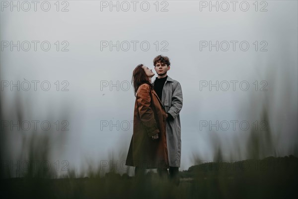 Couple in love in a foggy field. Relationship crisis and dramatic love concept