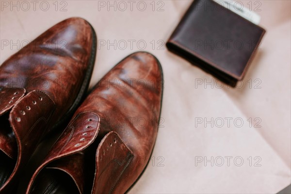 Brown men's shoes made of genuine leather and a brown leather wallet with money