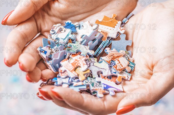 Woman holds a pile of puzzles in her hands. The concept of board educational games. Stay at home.