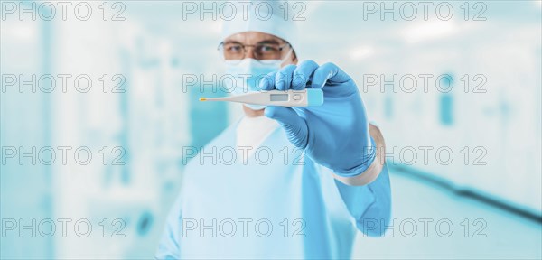 Portrait of a doctor in a medical center holding a thermometer. Medicine concept.