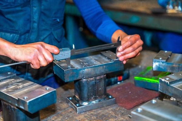 Operator with a cut finger working in a company with milling cutters in a numerical control workshop