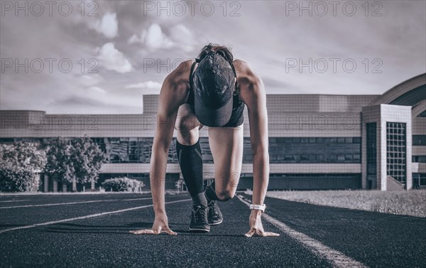Professional runner stands on the track and prepares for the start of the race. Sports concept.