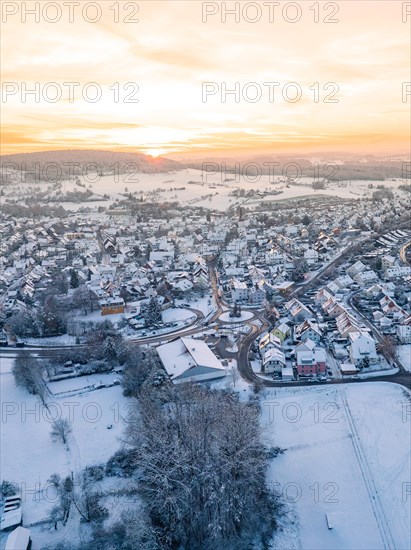 Winter evening over a small town with snow-covered roofs and streets