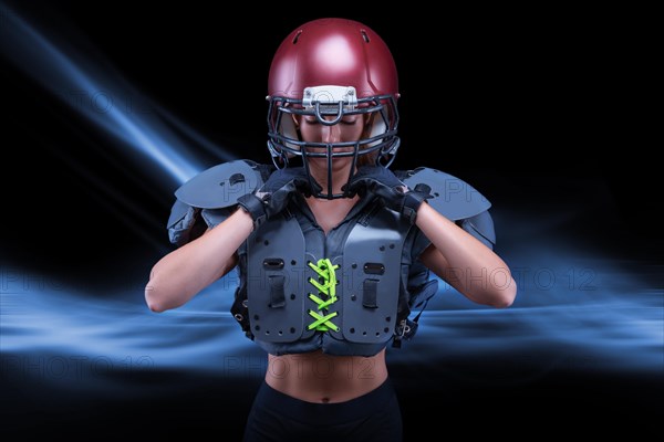 Brutal portrait of a girl in the uniform of an American football team player. Equipment advertising. Sports concept. Shoulder pads.