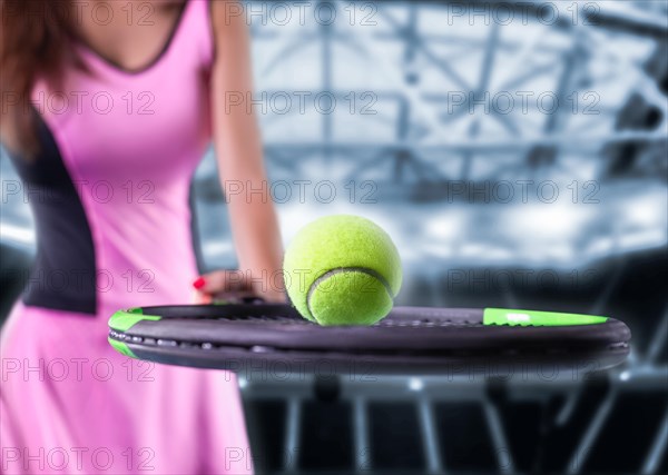 Portrait of a tennis player in a pink dress against the background of a sports arena.