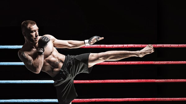 Kickboxer posing in the ring. Middle Kick. The concept of mma