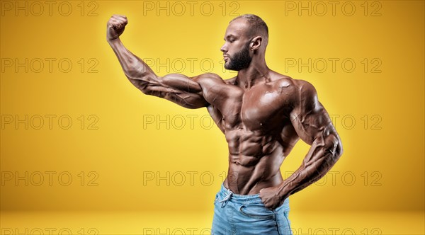 Isolated professional sportsman on a yellow background. Bodybuilding concept. Panorama. Advertising of a gym and sports nutrition.