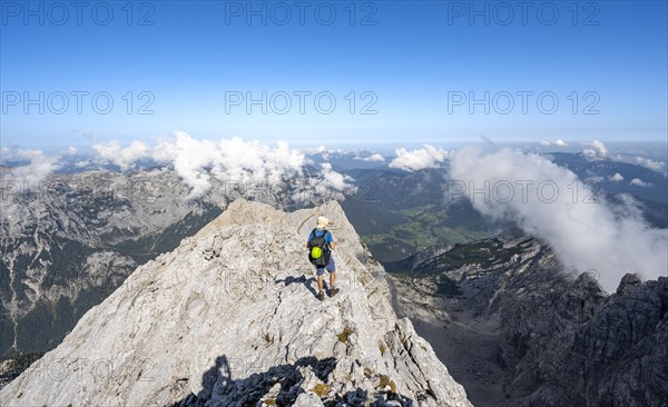 Mountaineer on a rocky path with mountain panorama