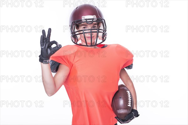Woman in the uniform of an American football team player shows the OK sign. Sports concept.