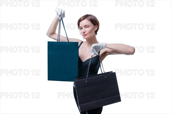 Stylish tall girl in white gloves demonstrates a black luxury package. The concept of safe shopping during a pandemic