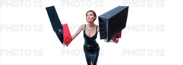 Cheerful positive girl jumps up with happiness and waving shopping bags. The concept of holiday gifts