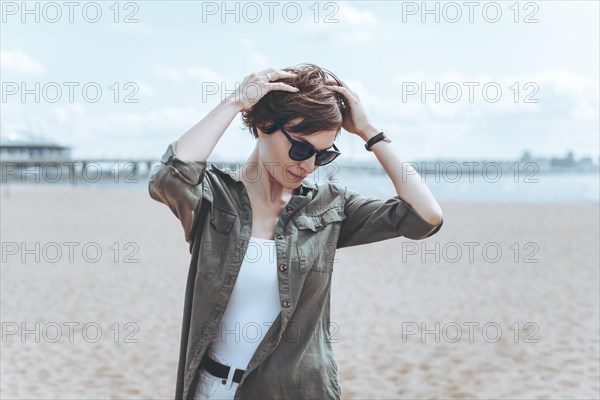 Image of a beautiful woman on the beach of the Gulf of Finland in St. Petersburg. Windy weather. Happiness