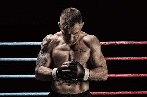 Mixed martial artist posing in boxing ring. Concept of mma