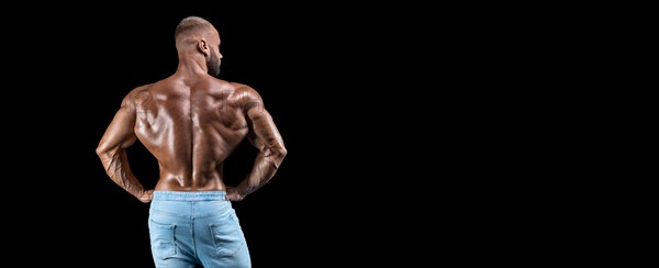 Isolated muscular man on a black background. Bodybuilding and fitness concept. Panorama.