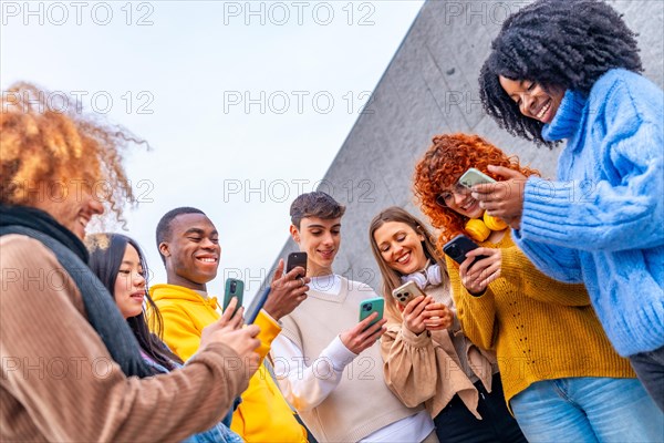 Low angle view of a group of friends using phone in the city