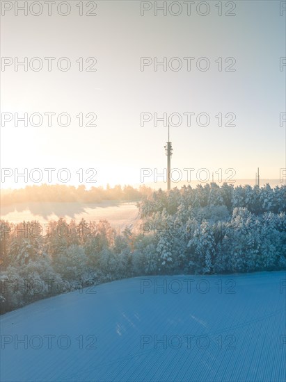 A peaceful winter morning dawns over snow-covered fields and radio towers