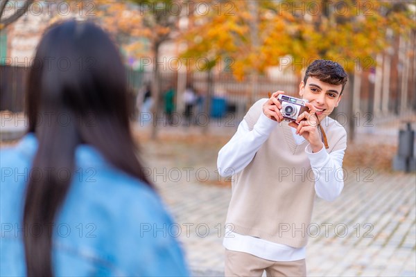 Friends taking photos in the city street using a digital camera