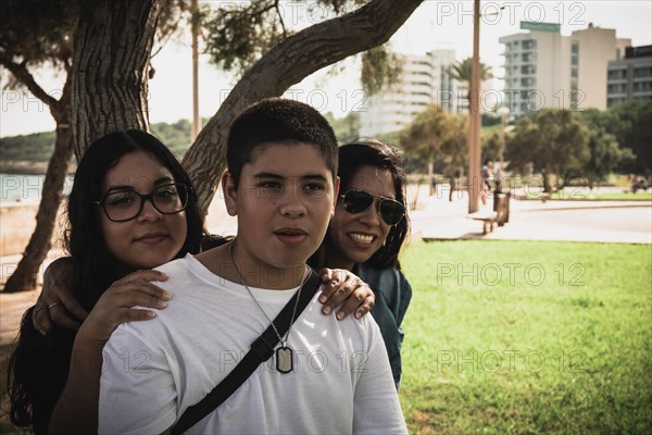 Cheerful group of young Latinos smiling at the camera in the open air